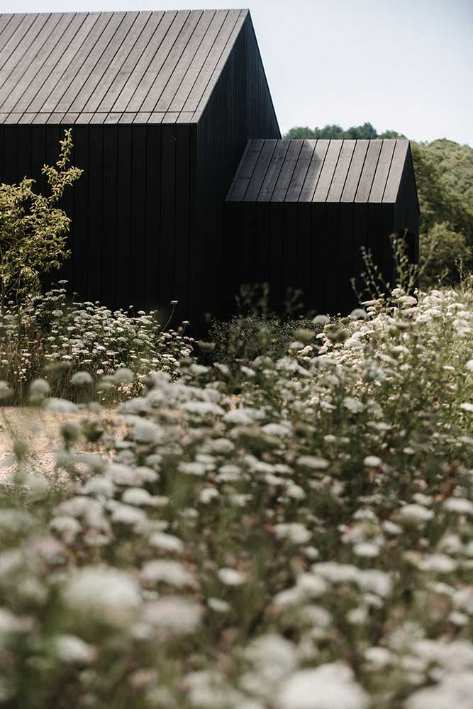 Meadow planting around black timber barn